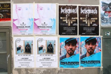 STOCKHOLM, SWEDEN - AUGUST 23, 2018: Posters for concerts and other events on a wall in Sodermalm district of Stockholm, Sweden. clipart