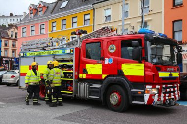 COBH, IRELAND - 4 Temmuz 2024: İrlanda 'nın Cobh şehrinde, İskandinav itfaiye aracının yanında duran itfaiyeciler.