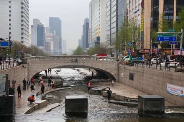 SEOUL, Güney Kore - 9 Nisan 2023: İnsanlar yağmurlu bir günde Seul şehir merkezindeki Cheonggyecheon akarsularını ziyaret ediyor..