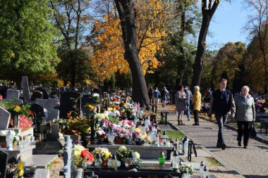 BYTOM, POLAND - 2 Kasım 2023: Polonya 'da Azizler Günü' nde (Wszystkich Swietych) bir mezarlığı ziyaret edenler.