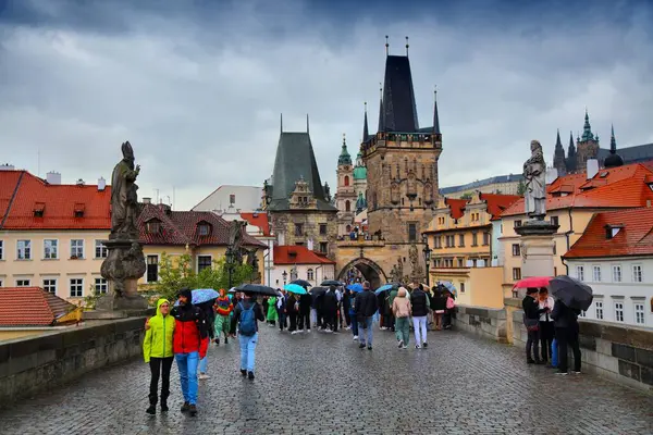 stock image PRAGUE, CZECH REPUBLIC - MAY 3, 2024: Crowd of tourists visits Charles Bridge (Karluv Most) in rainy Prague, Czech Republic.