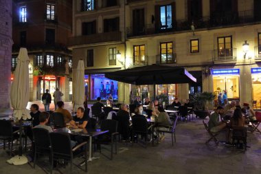 BARCELONA, İSPAN - 7 Ekim 2021: İnsanlar geceleri İspanya 'nın El Born semtindeki kaldırım kafesinde oturuyor. Barselona İspanya 'nın en büyük ikinci şehridir..