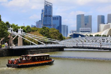 Singapur Şehri, ŞARKI - 13 Mart 2024: Singapur Nehri 'nde Cavenagh Köprüsü' ne yaklaşan bir tur teknesi.