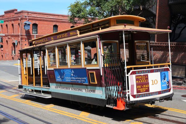 SAN FRANCISCO, USA - APRIL 8, 2014: Historic cable car in San Francisco, USA. Famous SF streetcars began operation in 1878. Alcatraz can be seen in background.