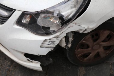 Ön tamponu hasarlı ve farları kırık klasik beyaz bir araba. Küçük bir kaza sonucu - İtalya 'da ufak bir kaza..