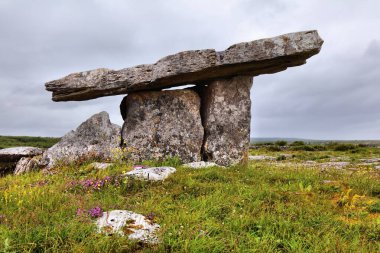 İrlanda 'da Poulnabrone Dolmen. Burren, County Clare 'deki taş devri portalı mezarı. İrlanda yazında yağmurlu bir gün.