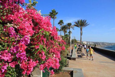 Büyük Kanarya, İspanya - 1 Aralık 2015: İnsanlar Maspalomalar, Gran Kanarya, İspanya 'daki Playa Ingles okyanus manzaralı gezinti güvertesini ziyaret ediyor.