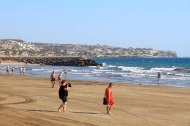 PLAYA INGLES, İspanya - 1 Aralık 2015: İnsanlar Maspalomas, Gran Canaria, İspanya 'daki Playa Ingles plajını ziyaret ediyor. Kanarya Adaları 2014 yılında 12,9 milyon ziyaretçi rekoru kırdı..