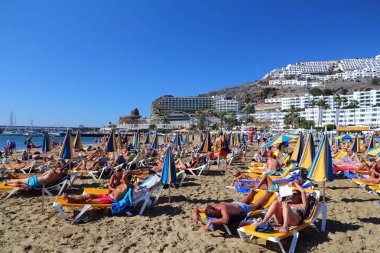 Granan Kanarya, İspanya - 2 Aralık 2015: İnsanlar güneşli bir günde İspanya 'nın Gran Canaria şehrinde Porto Riko Sahili' ni ziyaret ediyor.