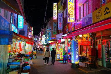 BUSAN, Güney Kore - 27 Mart 2023 İnsanlar Busan, Güney Kore şehir merkezindeki Bupyeon-dong 'un gece sokaklarını ziyaret ediyor.