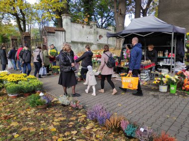 BYTOM, POLAND - 1 Kasım 2023: İnsanlar Polonya 'nın Bytom kentinde Azizler Günü (Lehçe: Dzien Wszystkich Swietych) sırasında çiçek ve mezar mumları satın alır.