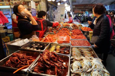 SEOUL, Güney Kore - 7 Nisan 2023: İnsanlar Güney Kore 'nin Jongno bölgesindeki Gwangjang Market' in balık ve kimchi yemek bölümünü ziyaret ediyor.