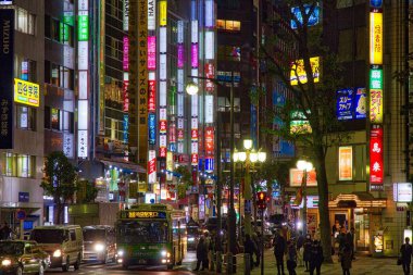 TOKYO, JAPAN - NOVEMBER 29, 2016: People visit Tokyo city Ikebukuro district at night. Ikebukuro is a commercial and entertainment district in Toshima, Tokyo. clipart