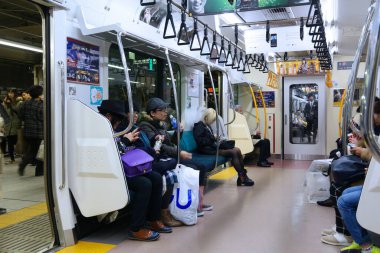 TOKYO, JAPONYA - 3 Aralık 2016: Tokyo, Japonya 'da yerel banliyö trenine binen yolcular.