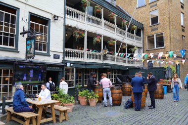 LONDON, UK - JULY 8, 2024: People visit The George Inn pub in Southwark district of London, UK. It is the only surviving galleried London coaching inn. clipart