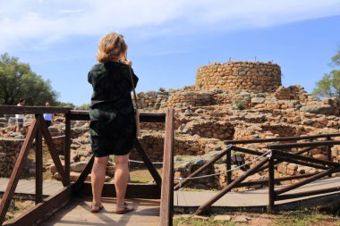 SARDINIA, İtalya - 25 Mayıs 2023: Turist, Arzachena yakınlarındaki Nuraghe La Prisgiona 'nın fotoğraflarını çekiyor. İtalya 'nın Sardunya kentindeki antik neolitik medeniyetin Nuragic anıtı.