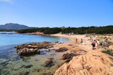 SARDINIA, İtalya - 24 Mayıs 2023: İnsanlar İtalya 'nın Sardunya adasındaki Arzachena' daki Capriccioli plajını ziyaret ediyor.