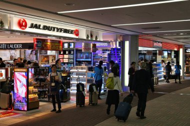 TOKYO, JAPAN - DECEMBER 5, 2016: People visit duty free shops at Narita Airport of Tokyo, Japan. Narita International Airport is the 2nd busiest airport of Japan. clipart