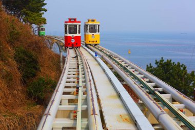 Capsule train line in Busan. Tourist attraction in South Korea. Namhae South Sea of Korea in background. clipart