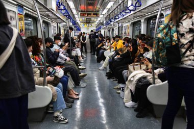 BUSAN, Güney Kore - 28 Mart 2023: Güney Kore 'deki Busan metro trenine binen yolcular.