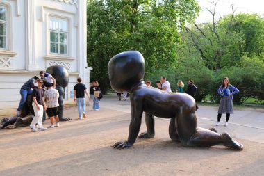 PRAG, CZECH REPUBLIC - 4 Mayıs 2024: İnsanlar Çek Cumhuriyeti Prag 'da David Cerny' nin emekleyen bebekler kamu alanı heykellerini ziyaret ediyor.