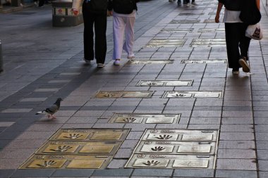 BUSAN, SOUTH KOREA - MARCH 27, 2023: People visit film maker hand prints commemorating Busan International Film Festival on BIFF Square in downtown Busan, South Korea. clipart