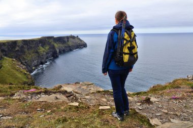 Anne kadın turistin uçurumları İrlanda 'nın Clare ilçesindeki yaz manzarasının yürüyüş manzarasının keyfini çıkarıyor..