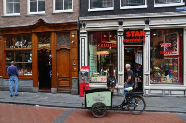 AMSTERDAM, NETHERLANDS - 10 Temmuz 2017: İnsanlar Amsterdam 'daki Warmoesstraat alışveriş caddesini ziyaret ediyor.