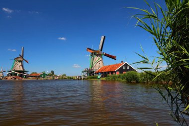 Windmills in Netherlands. Old industrial architecture in Zaanse Schans rural area in Zaandam. clipart