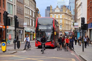 LONDON, İngiltere - 8 Temmuz 2024: Borough High Street 'teki bisikletçiler ve çift katlı otobüs trafiği Southwark, Londra, İngiltere' de yağmurlu bir günde.