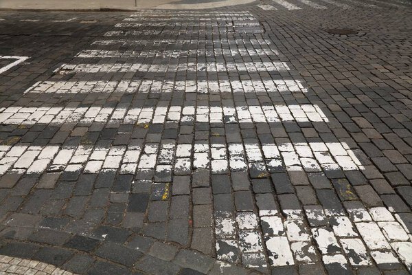 Пражский пешеходный переход раскрашен на булыжнике старого города. Транспортная инфраструктура в Праге, Чехия.