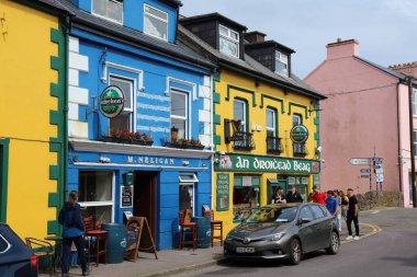 DİNGLE, IRELAND - 2 Temmuz 2024: İrlanda Kerry ilçesindeki Dingle Yarımadası 'nda insanlar Dingle kasabasının renkli ana caddesini ziyaret ediyor.