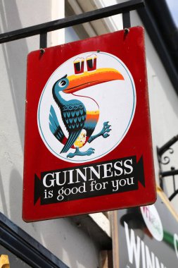 ADARE, IRELAND - 30 HAZİRAN 2024: Guinness For You Adinness bira reklamı İrlanda 'nın Limerick ilçesindeki Adare köyünde. Adare bir miras kasabası olarak gösterilir..