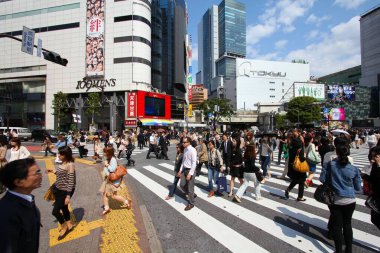 TOKYO, JAPONYAN - 11 Mayıs 2012: İnsanlar Shibuya, Tokyo 'daki Hachiko geçidinde yürür. Shibuya geçidi Tokyo 'daki en yoğun yerlerden biridir..
