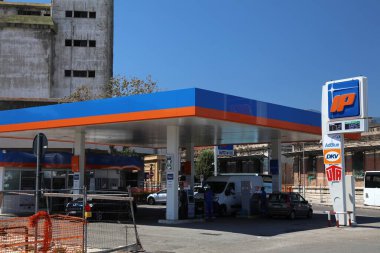 MESSINA, İtalya - 13 Ağustos 2024: Müşteriler arabalarını Messina, İtalya 'daki IP marka benzin istasyonundan dolduruyor. IP 'nin sahibi Gruppo Api enerji şirketi.