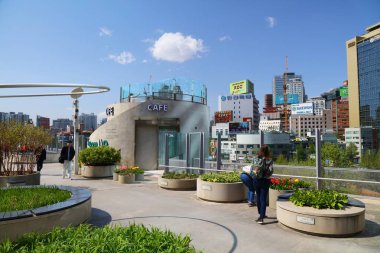 SEOUL, Güney Kore - 8 Nisan 2023: Seoullo 7017 Seul 'de insanlar yürür. Eski otoyol üst geçidi, Hollandalı kentsel tasarım şirketi MVRDV tarafından doğrusal parka çevrildi..