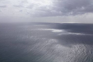 Fuerteventura 'dan görünen Atlantik Okyanusu üzerindeki ruhani atmosfer. Dramatik hava ve melankolik, kasvetli ruh haliyle gümüşi deniz manzarası.