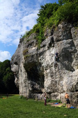 KRAKOW, POLAND - JULY 4, 2021: Climbing enthusiasts climb famous Dupa Slonia (Elephant Ass) rock in Jura rocks near Krakow, Poland.