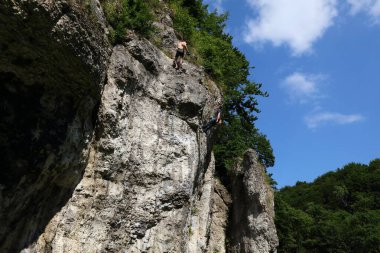 KRAKOW, POLAND - JULY 4, 2021: Climbing enthusiasts climb famous Dupa Slonia (Elephant Ass) rock in Jura rocks near Krakow, Poland.