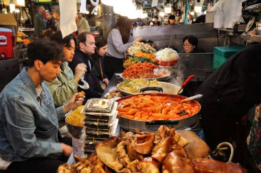 SEOUL, Güney Kore - 7 Nisan 2023: İnsanlar Güney Kore 'nin Jongno bölgesindeki Gwangjang Market' in sokak yemeklerinden hoşlanıyor.