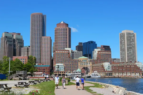 BOSTON, ABD - 9 Haziran 2013: İnsanlar güneşli bir yaz gününde Boston ufuk çizgisi manzaralı Güney Boston liman yürüyüşünü ziyaret ederler.