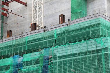Singapur 'da inşaat alanı. İskelesi koruyucu ağ ile kaplı..