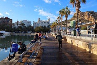 ALICANTE, İspanya - 15 Nisan 2025: İnsanlar Alicante, İspanya şehir merkezindeki Paseo de los Martire de la Libertad liman girişini ziyaret ediyor.