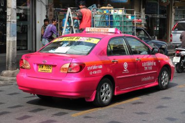 BANGKOK, THAILAND - 25 ARALIK 2013: Pembe Toyota Altis taksi Bangkok, Tayland 'da bir sokakta.