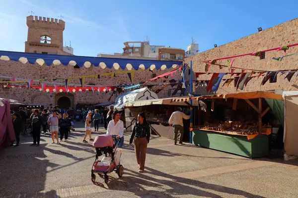 SANTA POLA, İspanya - 17 Nisan 2025: İnsanlar İspanya 'nın Alicante ilindeki Santa Pola şatosunda bir ortaçağ fuarı, yerel eğlence ve alışveriş etkinliğini ziyaret ediyorlar.