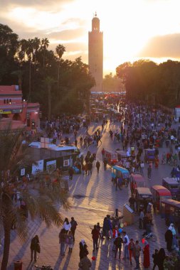 MARRAKESH, MOROCCO - 20 Şubat 2022: İnsanlar Marakeş 'in Jemaa el-Fnaa (Djemaa el Fna) meydanını ziyaret ediyor. Meydan, UNESCO İnsanlığın Soyut Mirasının Başyapıtı olarak listelendi.