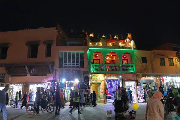 MARRAKESH, MOROCCO - 19 Şubat 2022: İnsanlar Marakeş 'in kare pazarı Jemaa el-Fnaa' yı (Djemaa el Fna) ziyaret ediyor. Meydan, UNESCO İnsanlığın Soyut Mirasının Başyapıtı olarak listelendi.