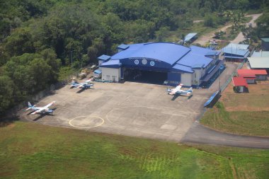 KOTA KINABALU, MALAYSIA - 8 Mart 2024: Malezya Kraliyet Polis Hava Kuvvetleri (Pasukan Gerakan Udara Polis Diraja Malaysia) hangarı ve Malezya 'daki Kota Kinabalu Havalimanı' nda park edilmiş uçaklar.