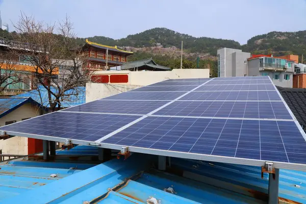 Küçük bir iş binasının çatısındaki güneş panelleri. Busan, Güney Kore 'de fotovoltaik enerji üretimi.