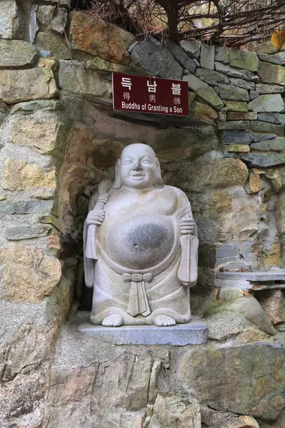 BUSAN, Güney Kore - 29 Mart 2023: Güney Kore Busan 'daki deniz kıyısındaki Haedong Yonggungsa Tapınağı' nda oğlu için dua etmek üzere ünlü Buda heykeli.